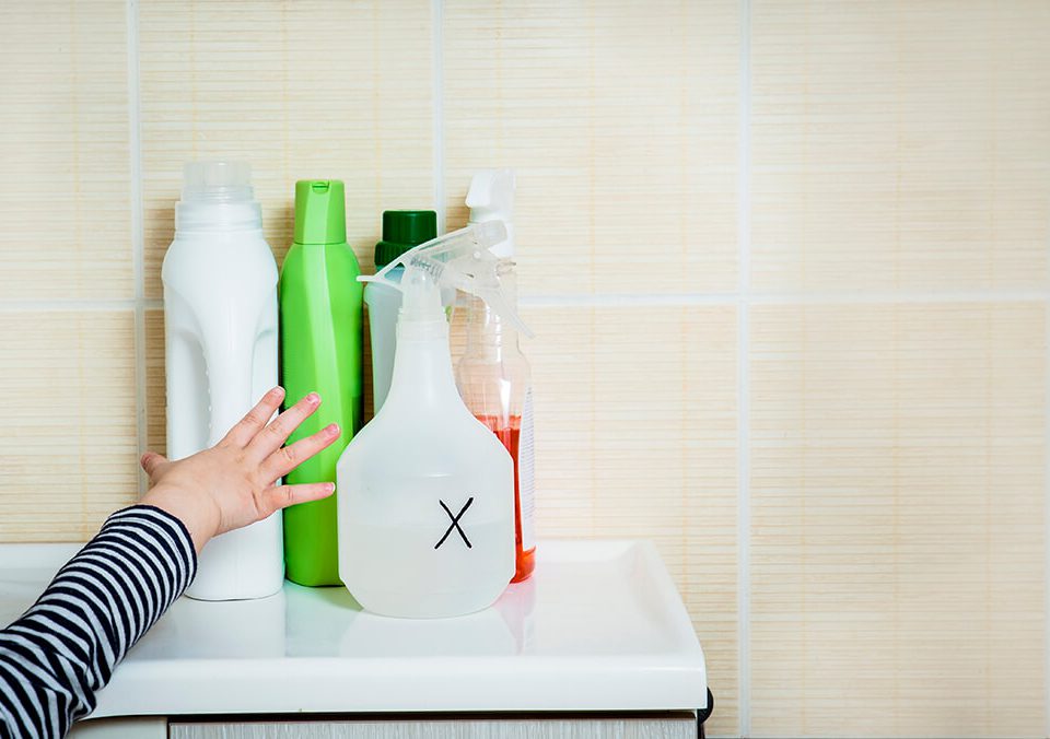 Child reaching for cleaning supplies