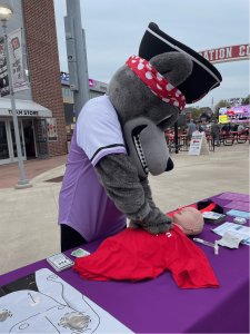 Erie Seawolves mascot practicing chest compressions at the Minutes Matter table at a recent Erie Seawolves game.