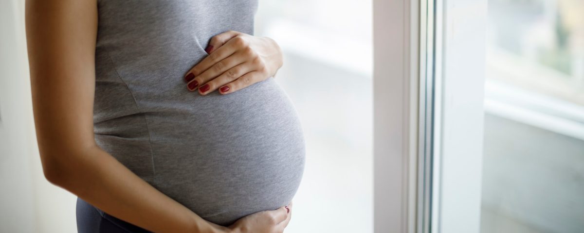 A pregnant woman with her hand on her stomach