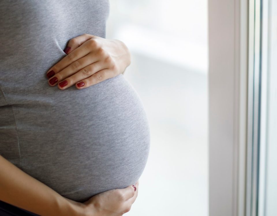 A pregnant woman with her hand on her stomach